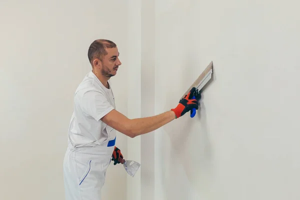 Trabajador Hombre Enyesa Pared Con Una Espátula Aplica Una Solución — Foto de Stock