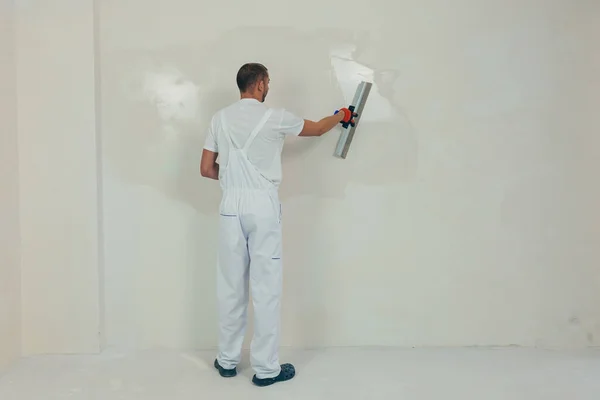 Trabajador Hombre Enyesa Pared Con Una Espátula Aplica Una Solución — Foto de Stock