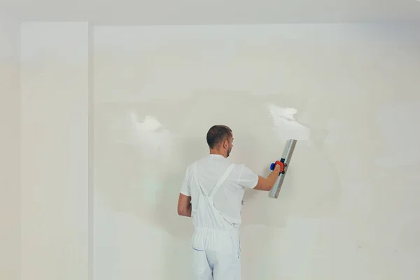 一名男工用铲子在墙上抹灰 并用水泥混合溶液 修理工把石膏放在干墙上 — 图库照片