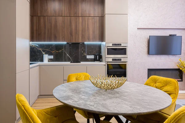 Interior of a stylish modern kitchen in pastel colors, gray, with an insert of black marble