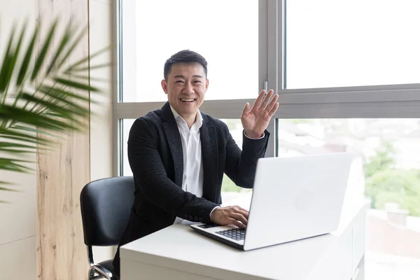 아시아 사업가는 노트북에서 일합니다 사무실에서 비디오 링크를 새로운 전략을 설명합니다 — 스톡 사진