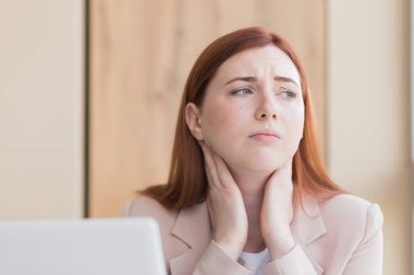 Kızıl saçlı bir iş kadınının yakın plan fotoğrafı. Şiddetli diş ağrısı ve bilgisayar başında baş ağrısı, aşırı çalışma, stres ve depresyon.