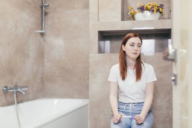 Genç, hayal kırıklığına uğramış bir kadın istenmeyen bir kadın tarafından banyoda yapılan hamilelik testinin pozitif ya da negatif sonucuna bakıyor. Hamile kadın evde üzgün ve hayal kırıklığına uğramış bir şekilde oturuyor.