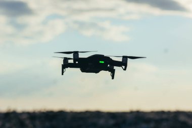 Gökyüzü arka planında gün batımlı drone silueti
