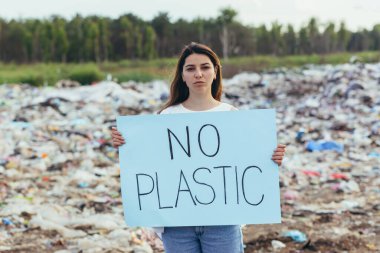 Kadın gönüllü, plastiksiz, aktivist, çevresel kirlilikle mücadele eden bir posteri protesto ediyor.