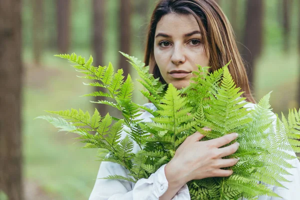 森林里的一个女人抱着一束蕨树 一个年轻的积极分子保护着森林 — 图库照片