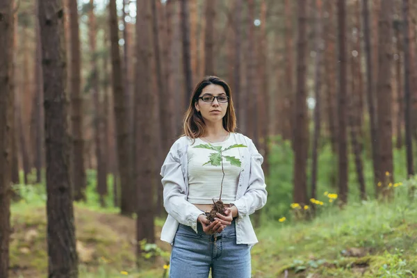 年轻的女性自愿地在森林里植树 手里拿着一棵橡树苗 — 图库照片