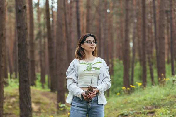 年轻的女性自愿地在森林里植树 手里拿着一棵橡树苗 — 图库照片