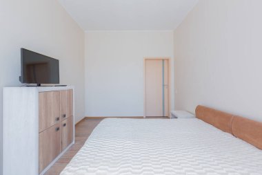 Bir yatak odasının içinde açık renkli büyük bir yatak odası.