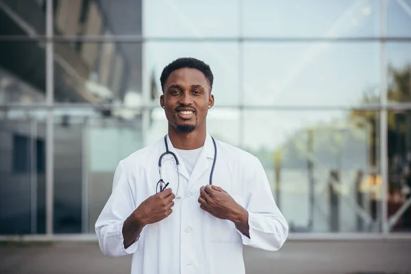 Portrait of an African doctor looking at camera and smiling in front of clinic