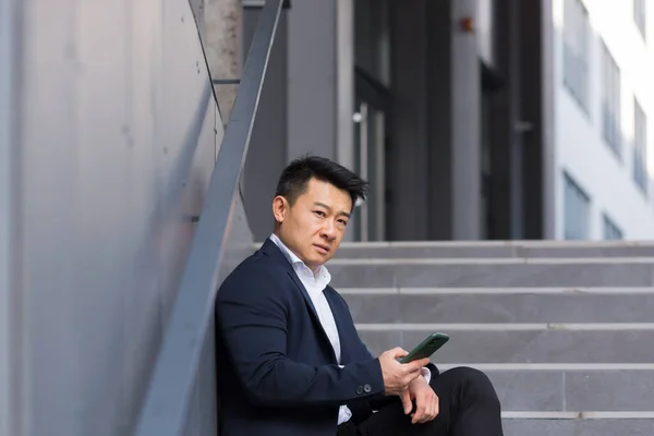 Asiatisk Affärsman Läser Dåliga Nyheter Från Telefonen Sitter Nära Kontoret — Stockfoto