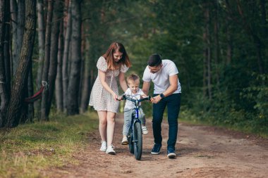 Ormanda piknik yapan genç bir aile, karı, koca ve küçük bir çocuk. Oğullarına bisiklet sürmeyi öğret.