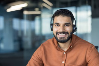 Modern bir ofiste kulaklık takan gülümseyen, müşteri hizmetleri, destek ve danışma sağlayan, çağrı merkezini, tele pazarlamayı ve online iletişim kavramlarını temsil eden çeşitli adamlar.
