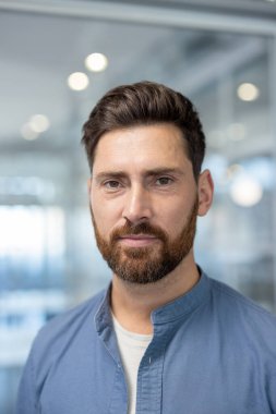 Kendine güvenen orta yaşlı iş adamı parlak, modern bir ofiste kafa resmi, akıllı-gündelik yönetici pozu liderlik, başarı, kararlılık ve profesyonel karizma.