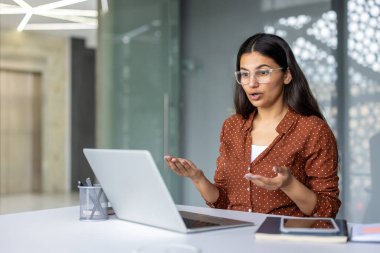 Genç iş kadını ya da öğrenci laptoptaki bir video görüşmesi sırasında şaşkınlıklarını dile getiriyor, ofis ya da ev ortamından uzaktan iletişim kuruyor.