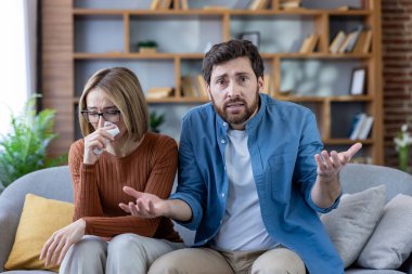 Evde gergin bir terapi seansında bir çift, ağlayan kadın, hayal kırıklığına uğramış erkek, ilişki problemlerini tartışıyor ve video aracılığıyla profesyonel rehberlik arıyor..