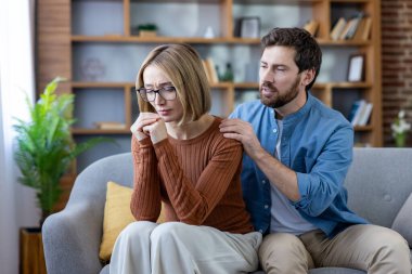 Üzgün bir kadına destek ve rahatlık sunan bir adam zor bir duygusal ya da ilişki sorunu sırasında üzgün, stresli ve empati duygularını resmediyor.