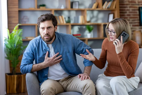 Kalp krizi geçiren bir adam. Koltuğunda sıkıntılı bir kadın otururken göğsünü tutuyor. Evde bir oturma odasında cep telefonuyla acil tıbbi yardım çağrısı yapıyor.