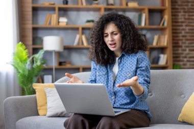 Kadın kendini stresli ve şaşkın hissediyor, evden uzakta çalışırken bilgisayarında bir hata olması, teknolojik sorunları ve destek ihtiyacını gösteriyor