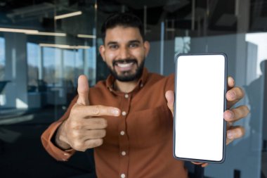 Uygulama tanıtımı veya web sitesi görüntülemesi için cep telefonunu boş beyaz ekran ile sunan genç işadamı, modeller ve dijital içerik reklamları için yer sunuyor