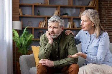 Olgun bir eş, sıkıntılı kocasını evdeki kanepede rahatlatır. Birlikte geçirdiğimiz zor ve duygusal bir anda empatik destek ve özenli bir dinleme sunar.