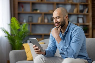 Modern bir kanepede rahatlayan mutlu bir milenyum adamı. Portatif bir tablette okurken ve dolaşırken gülümsüyor. Boş zamanların, bağlantıların ve evde eğlencenin tadını çıkarıyor.