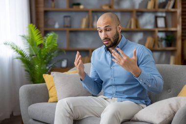 Rahat bir kanepede oturan bunalmış bir adam, evinden uzakta zor bir zamanda destek ve tavsiyeye ihtiyaç duyan, endişelerini ve endişelerini açık bir şekilde ifade ediyor.