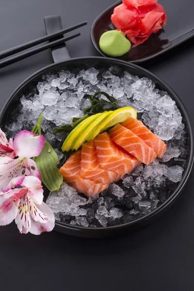 Salmone crudo sasimi con ghiaccio su fondo nero — Foto Stock