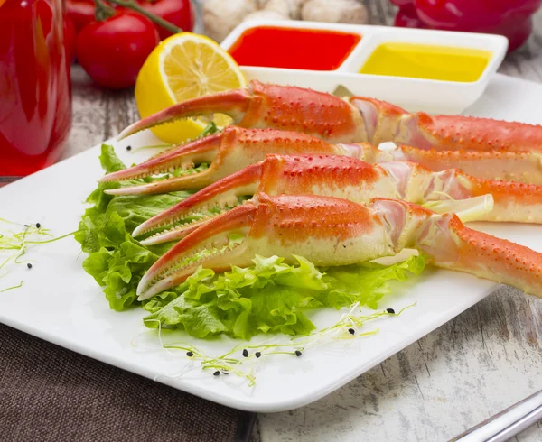 Boiled crab claws with sauce , lemon and cherry tomatoe with tasty drink over wooden background — Stock Photo, Image