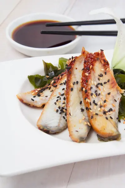 Sashimi di anguilla con salsa di soia su un piatto bianco su sfondo di legno — Foto Stock