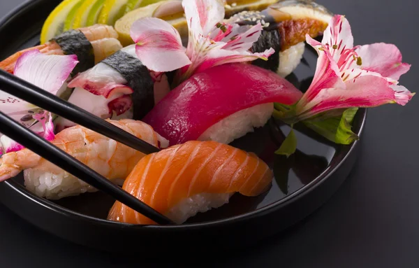 Sushi set on a black plate and black background — Stock Photo, Image