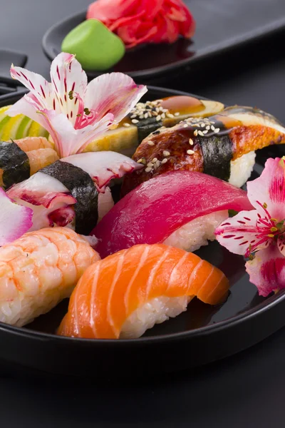 Sushi set on a black plate and black background — Stock Photo, Image