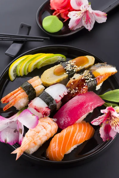 Sushi set on a black plate and black background — Stock Photo, Image