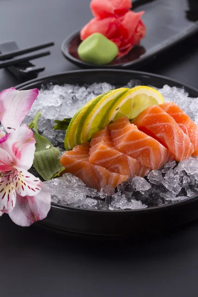 Salmone crudo sasimi con ghiaccio su fondo nero — Foto Stock