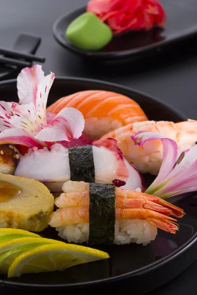 Sushi na černém plátu a černým pozadím — Stock fotografie