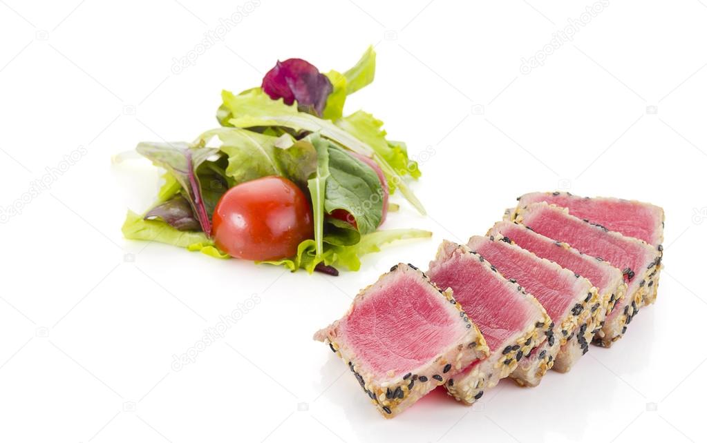 Tuna filet with sesame and vegetables over white background