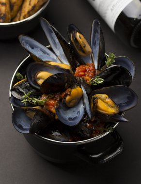 Siyah arka plan üzerinde yemek yemek ve Fransız baget ve şarap bakır midye