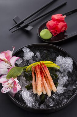 Japon mutfağı, karides Sashimi buzlu zencefil ve wasabi siyah bir plaka üzerinde