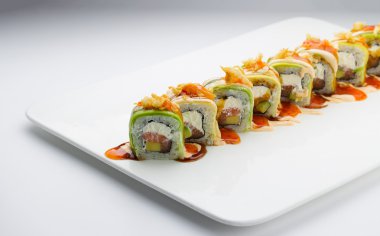Suşi avokado somon ve peynir ile. Crunch Roll. Lezzetli soslar ile. Beyaz arka plan üzerinde bir tabağa.