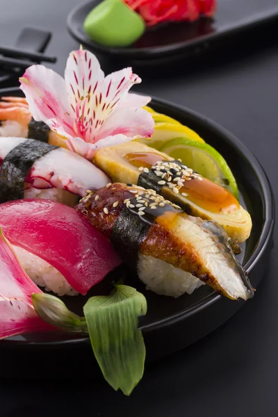 Sushi na czarnej płycie i czarne tło — Zdjęcie stockowe