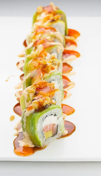 Sushi met zalm avocado en kaas. Crunch Roll. Met heerlijke sauzen. Op een plaat op witte achtergrond. — Stockfoto