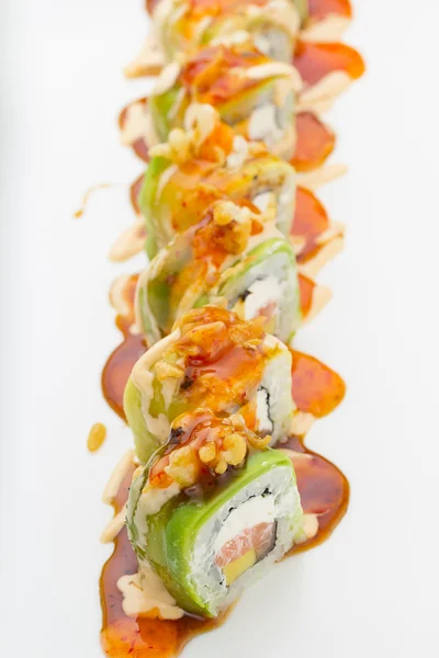 Sushi com salmão de abacate e queijo. Crunch Roll. Com deliciosos molhos. Em uma chapa sobre fundo branco . — Fotografia de Stock