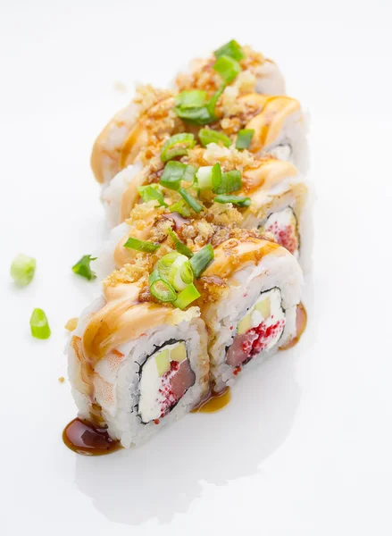 Sushi s krevety, avokádo lososem a sýrem nasypala s zelenou cibulkou. Tíseň Roll. S lahodnými omáčkami. Nad bílým pozadím. — Stock fotografie