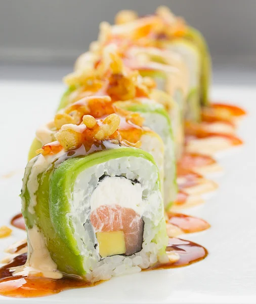 Sushi met zalm avocado en kaas. Crunch Roll. Met heerlijke sauzen. Op een plaat op witte achtergrond. — Stockfoto