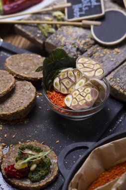 Rustik arka plan üzerinde sarımsak birçok başka baharatlar ile dilimlenmiş