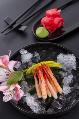 Japon mutfağı, karides Sashimi buzlu zencefil ve wasabi siyah bir plaka üzerinde
