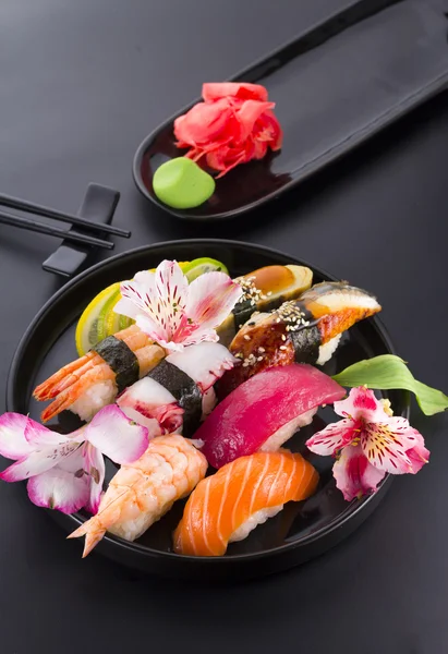 Sushi auf schwarzem Teller und schwarzem Hintergrund — Stockfoto