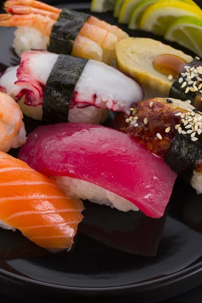 Sushi set on a black plate and black background — Stock Photo, Image