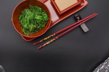 Siyah arka plan üzerinde fındık soslu chuka salatası