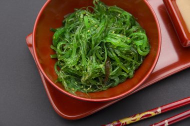 Siyah arka plan üzerinde fındık soslu chuka salatası